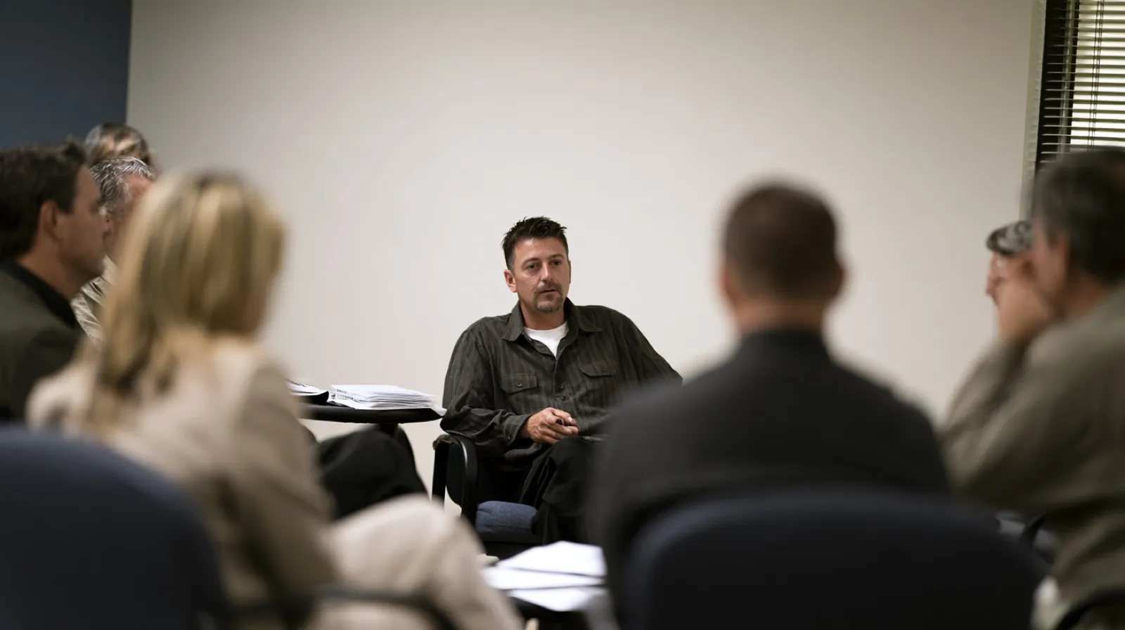 Man participating in a counseling or support session representing rehabilitation and personal progress that may be presented during sentencing.