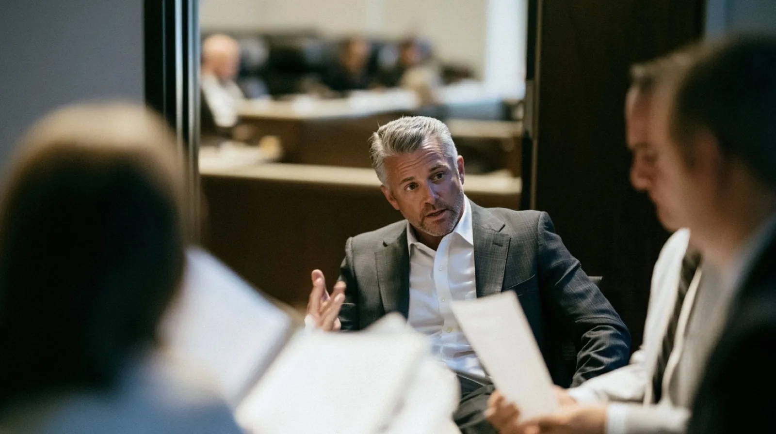 Defense attorney reviewing documents with a client concerned about reporting a criminal conviction to a Nevada licensing board.