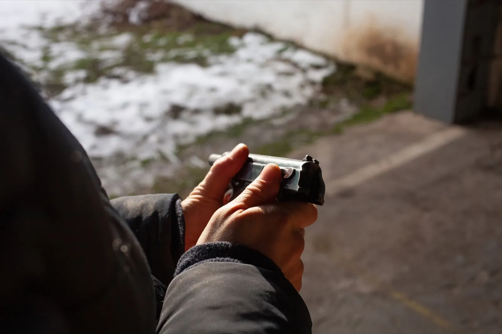 A man reloads a gun. out of the door, shooting range. Murder, danger, firearms