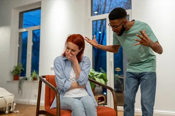 Angry African American man husband abuser yelling at upset crying wife at home