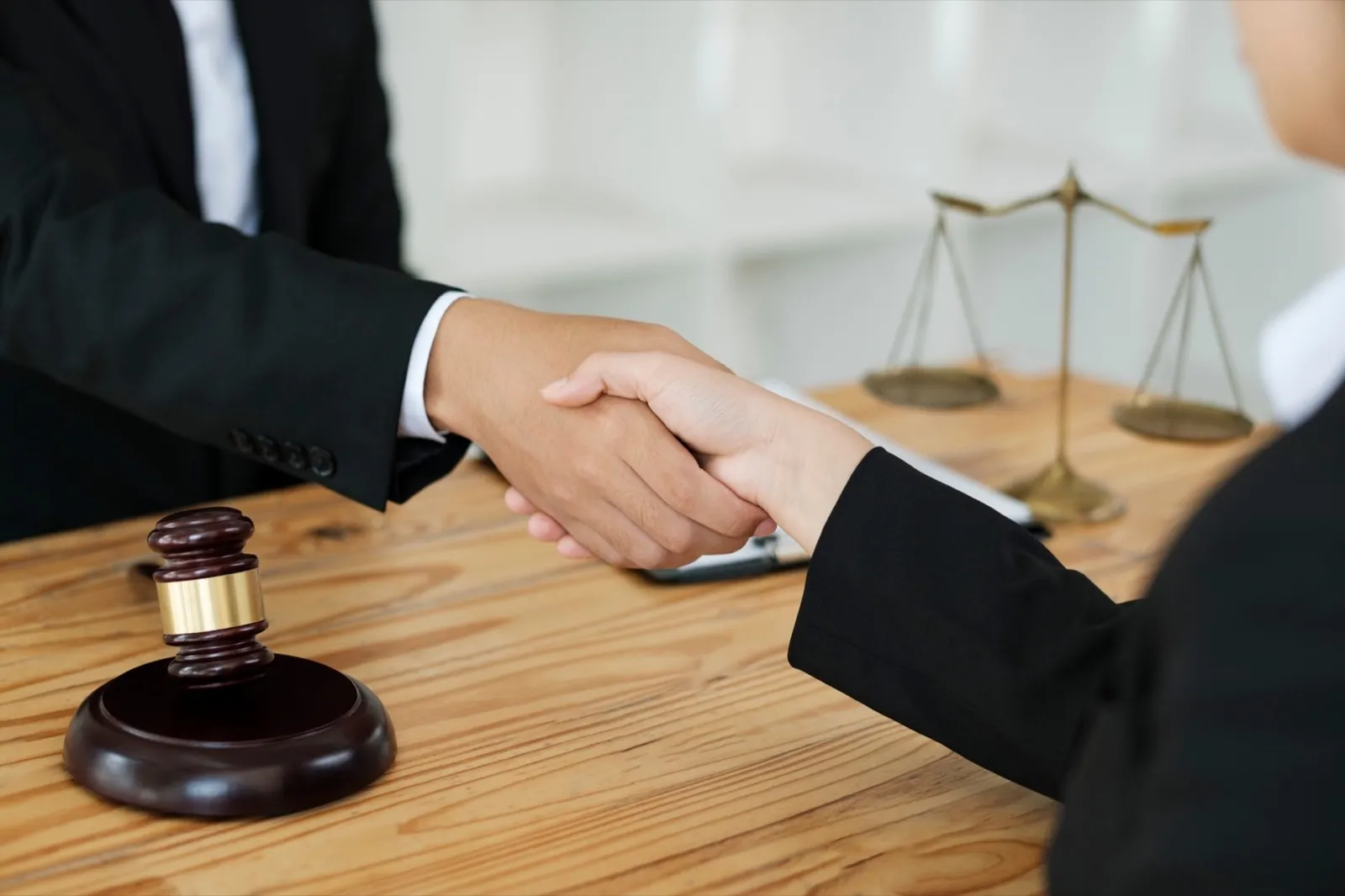Attorney shaking hands with client for agreement regarding case in court.