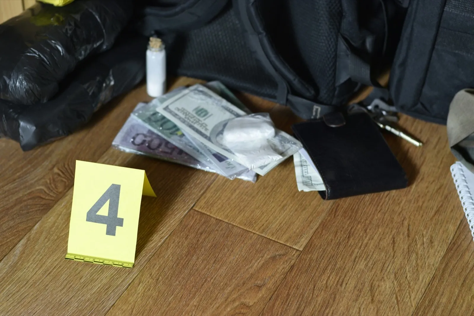 Big heroin packets and packs of money bills as evidence in crime scene investigation process close