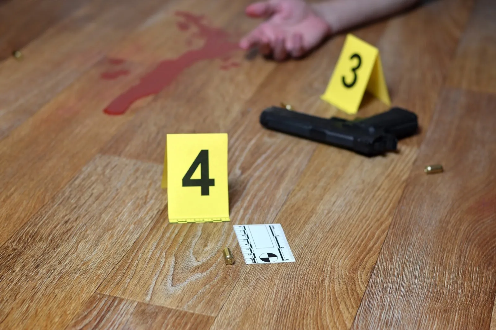 Bloody crime scene with dead body and gun on floor