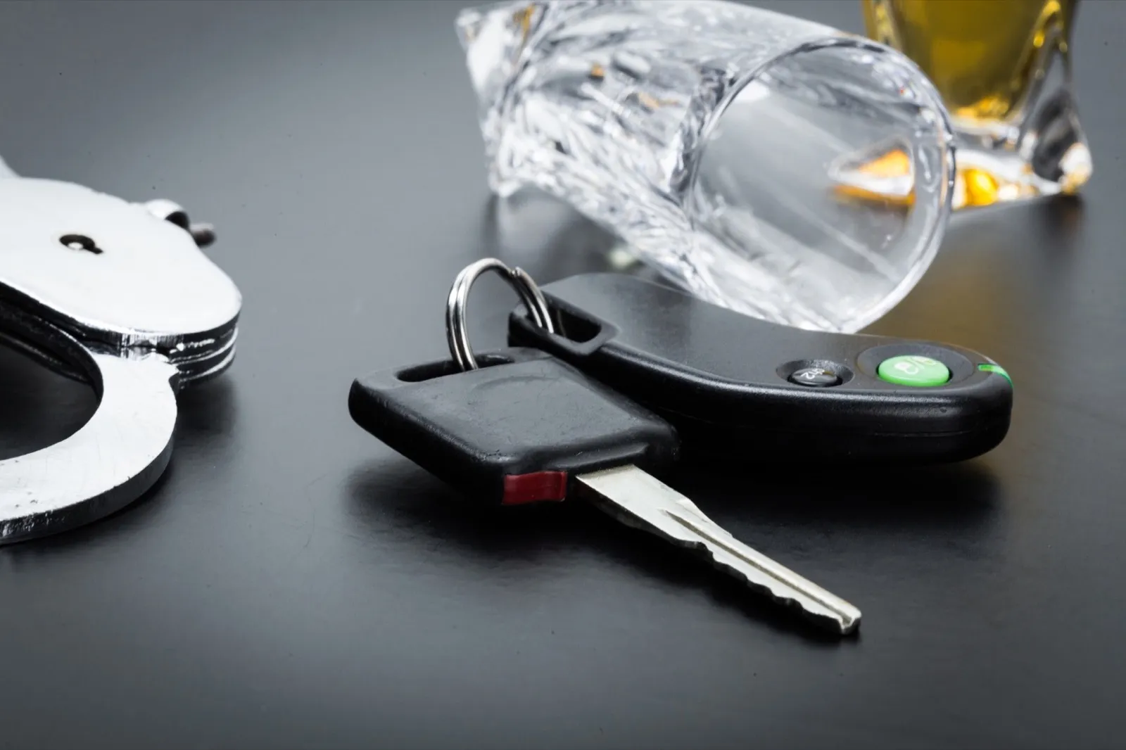 Car key on the bar with spilled alcohol