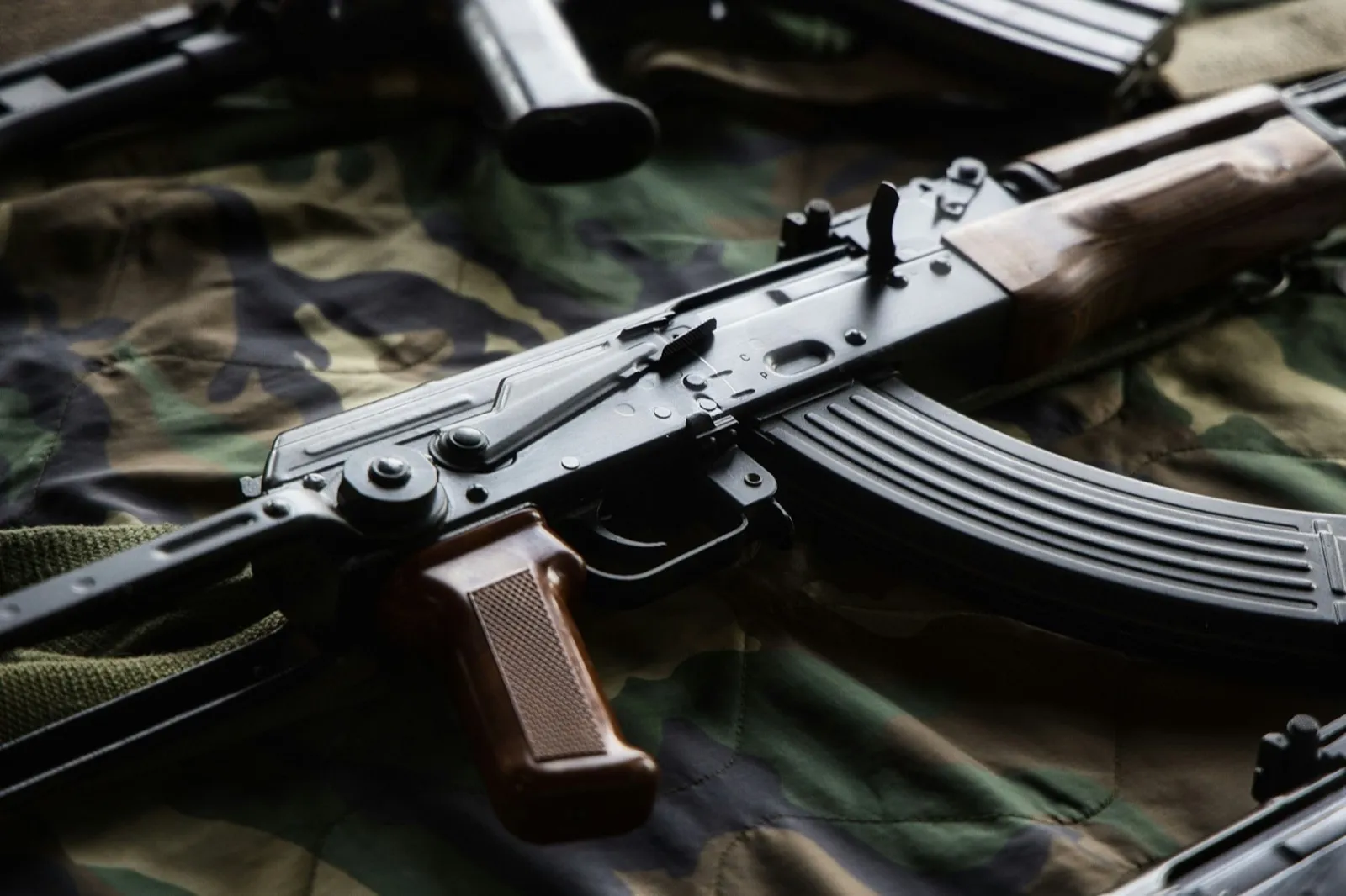 Close up of an AK47 firearm on a camouflage pattern fabric