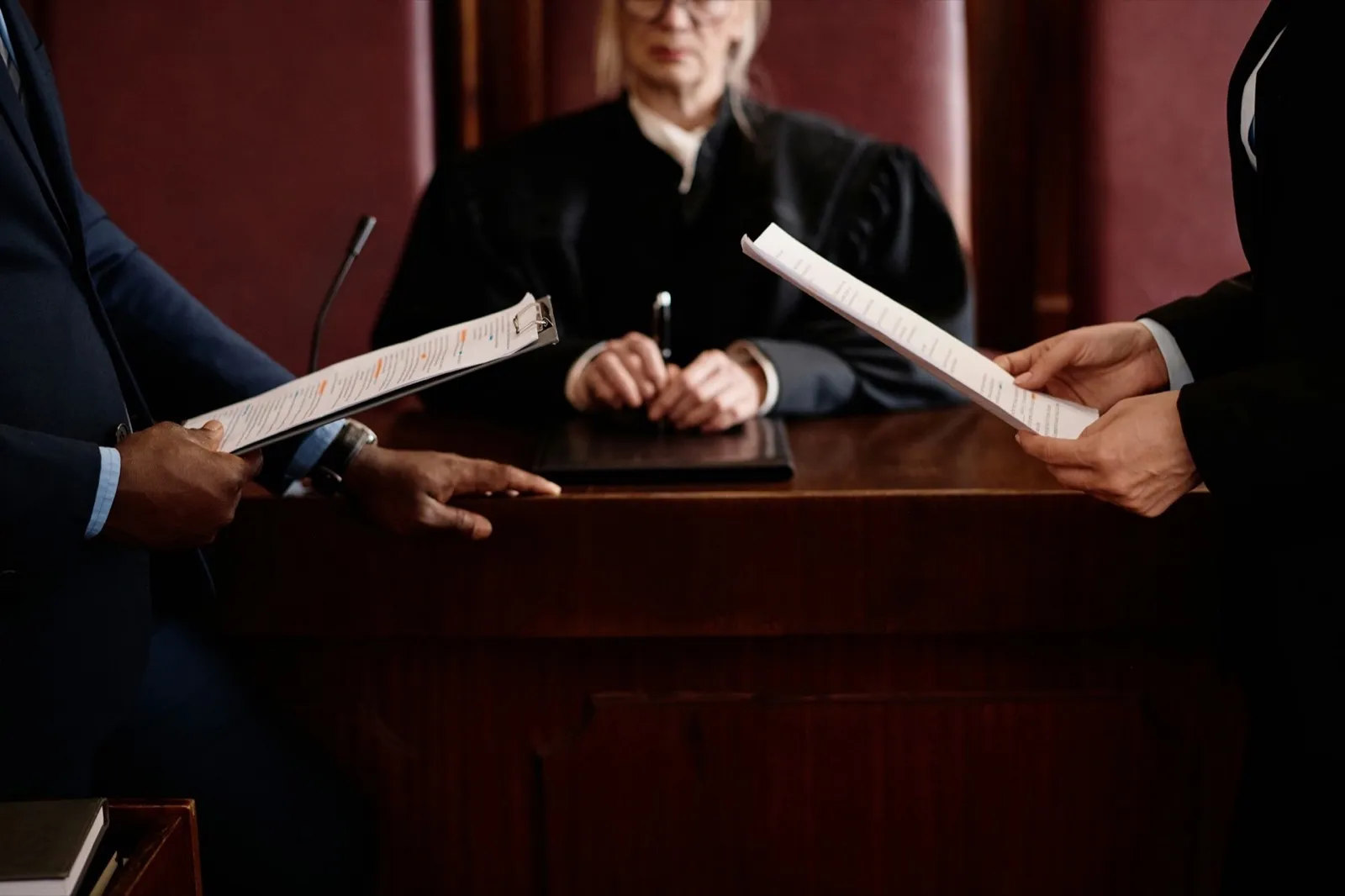 Close-up of prosecution and defense sides holding juridical documents