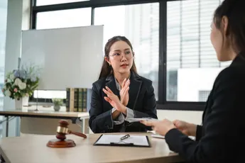 Confident Female Lawyer Denies Corruption Allegations in Modern Office Setting During Client