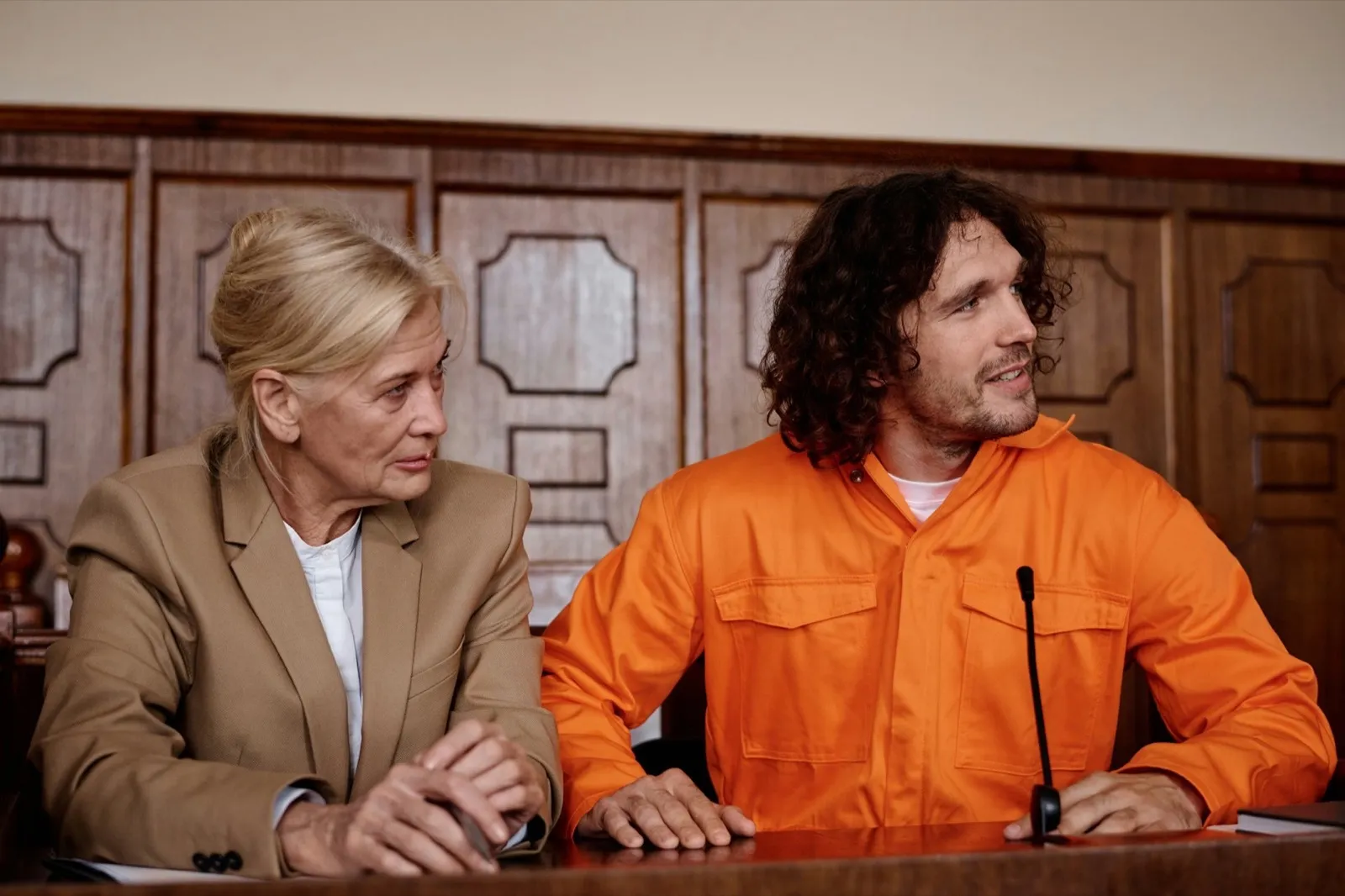 Confident mature attorney and her defendant looking at judge during trial