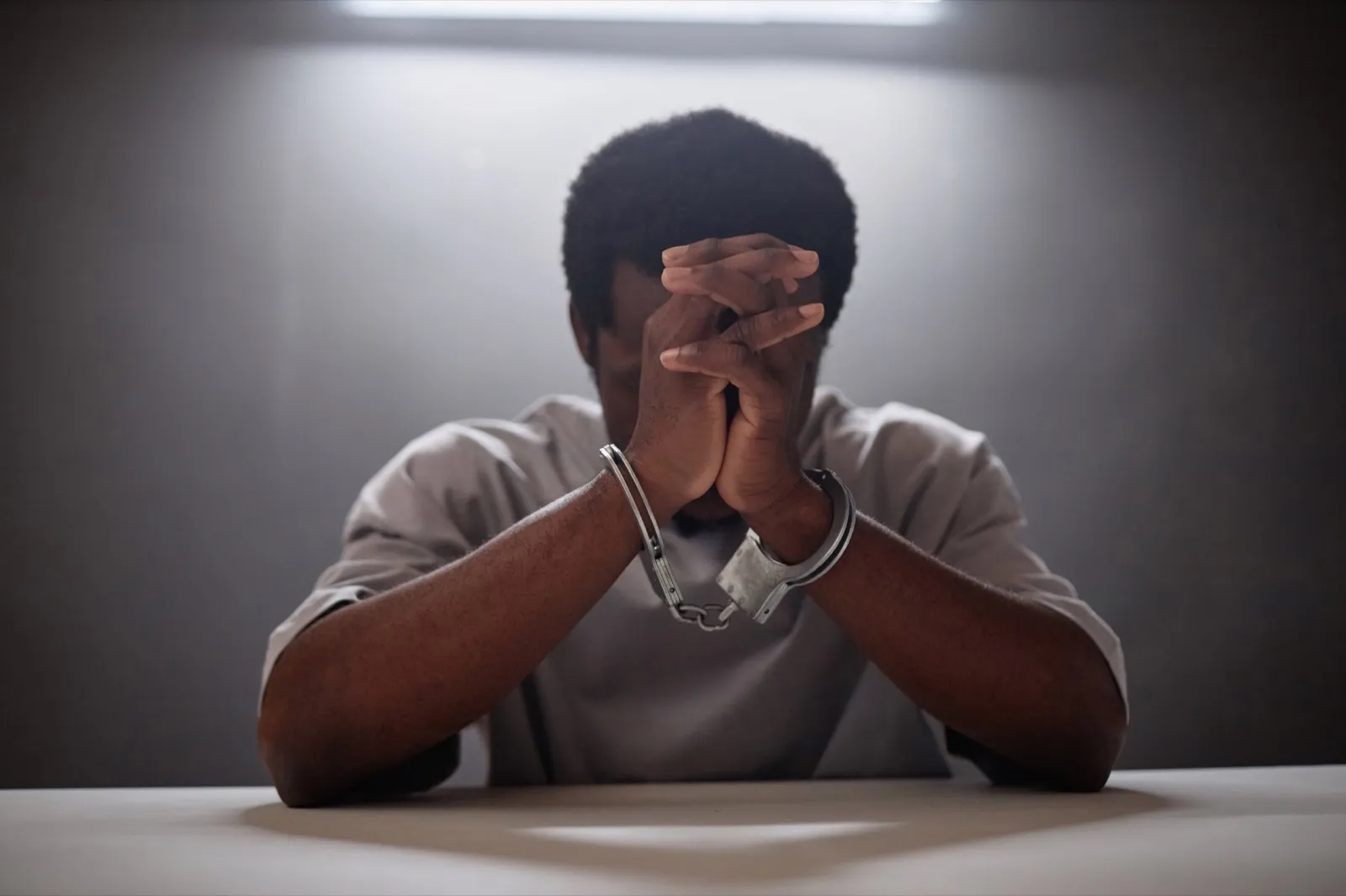 Criminal wearing handcuffs crying in remorse