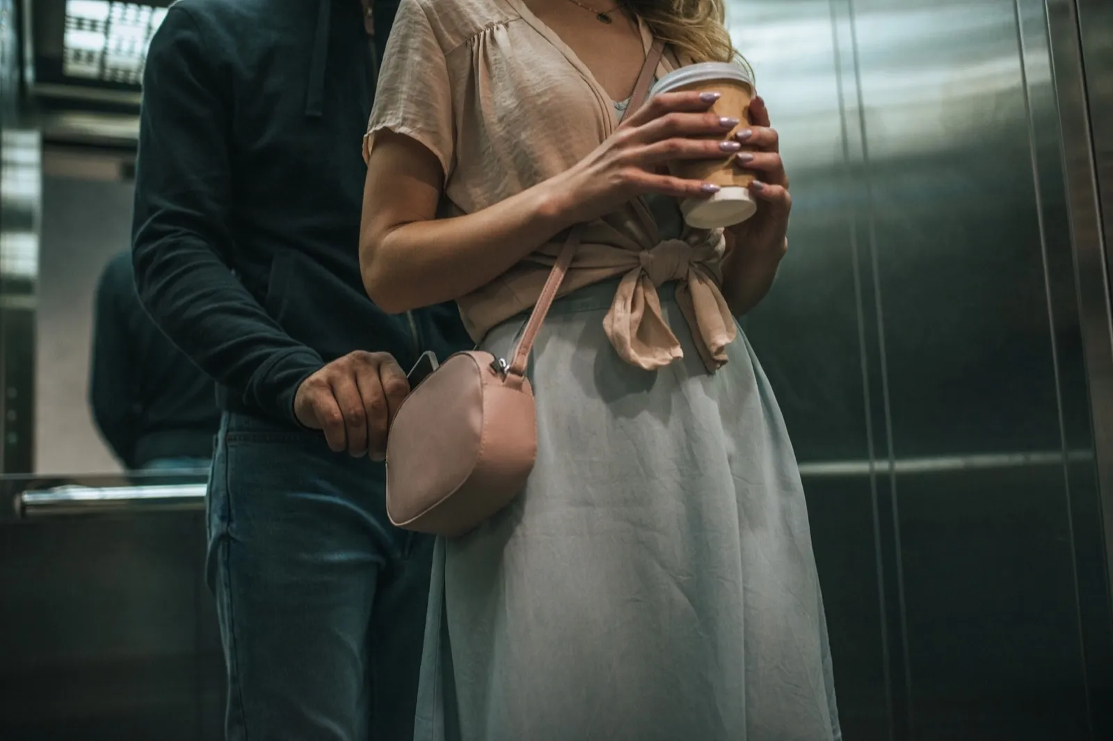 cropped view of robbery pickpocketing smartphone from womans bag in elevator