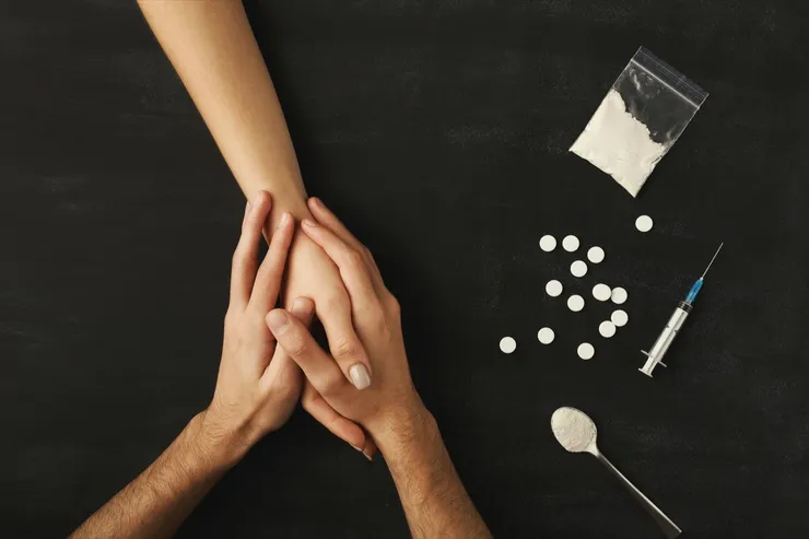 Drug addict hands on dark table