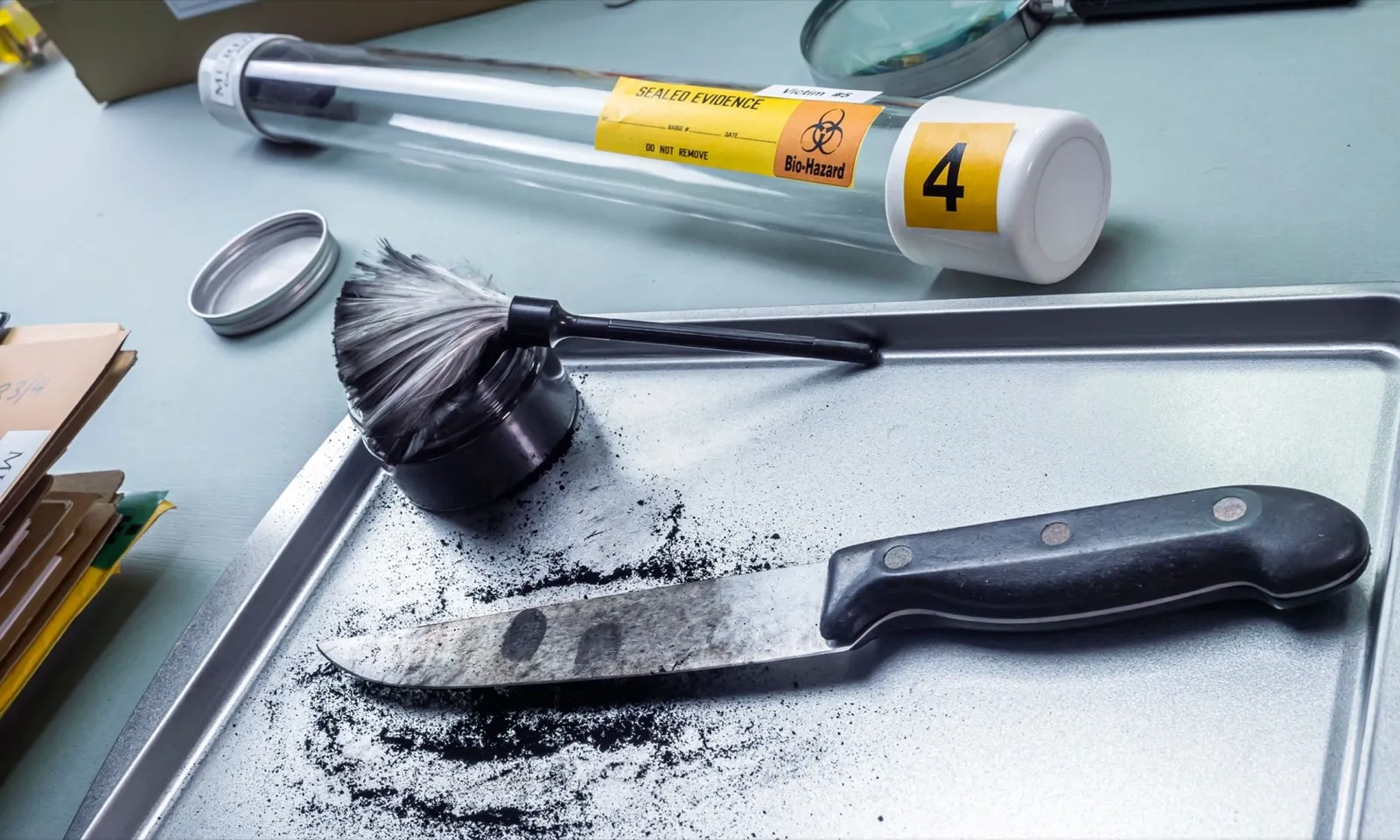 Fingerprint development on a knife involved in a homicide in a crime lab, conceptual image