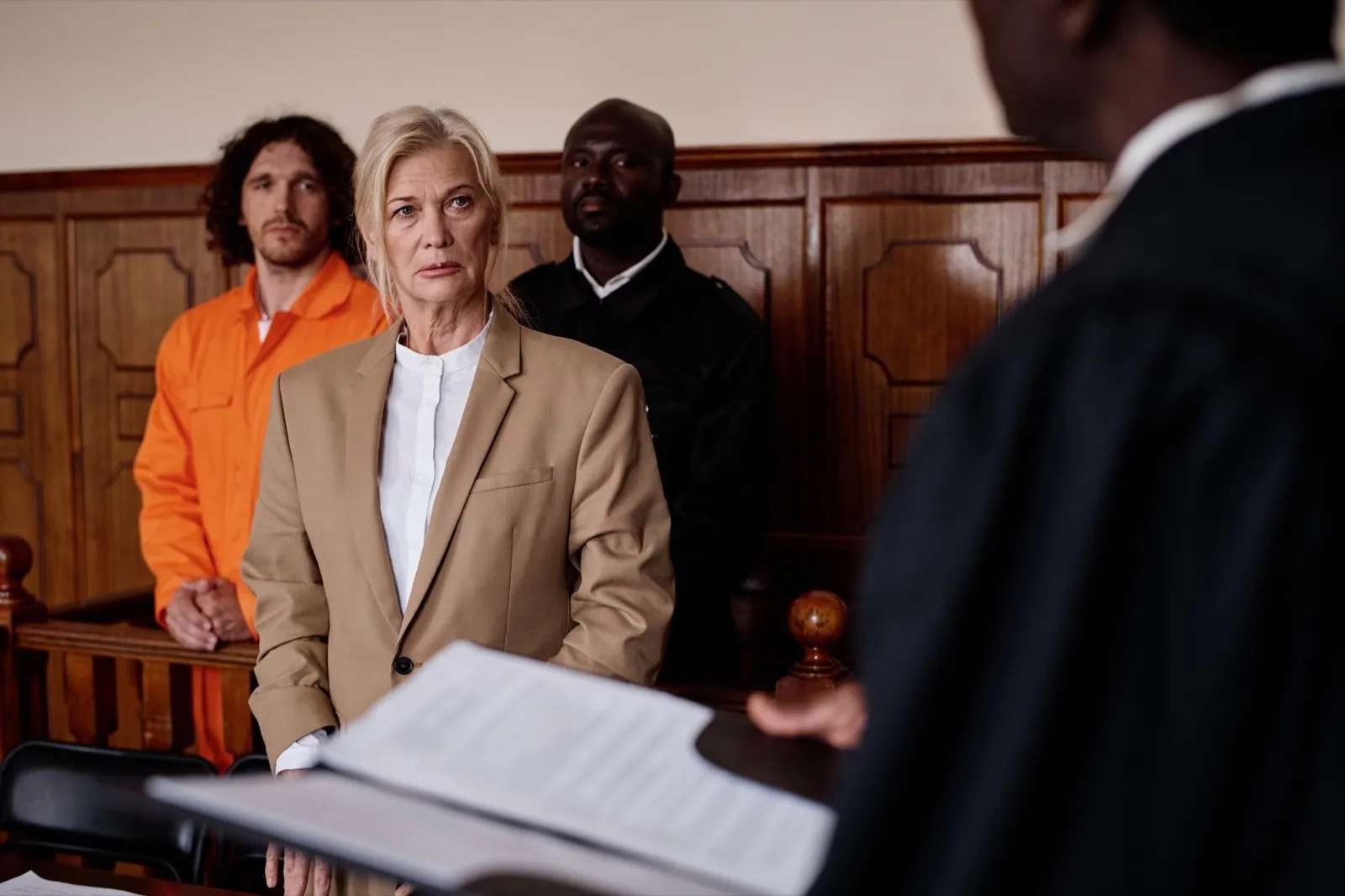 Focus on mature female attorney listening to impartial judge with open folder