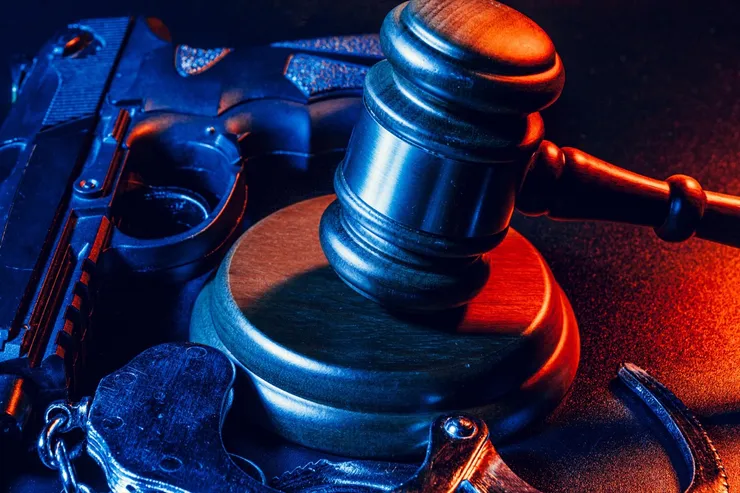 Gun and judge's gavel on the table. Crime, robbery, attack concept