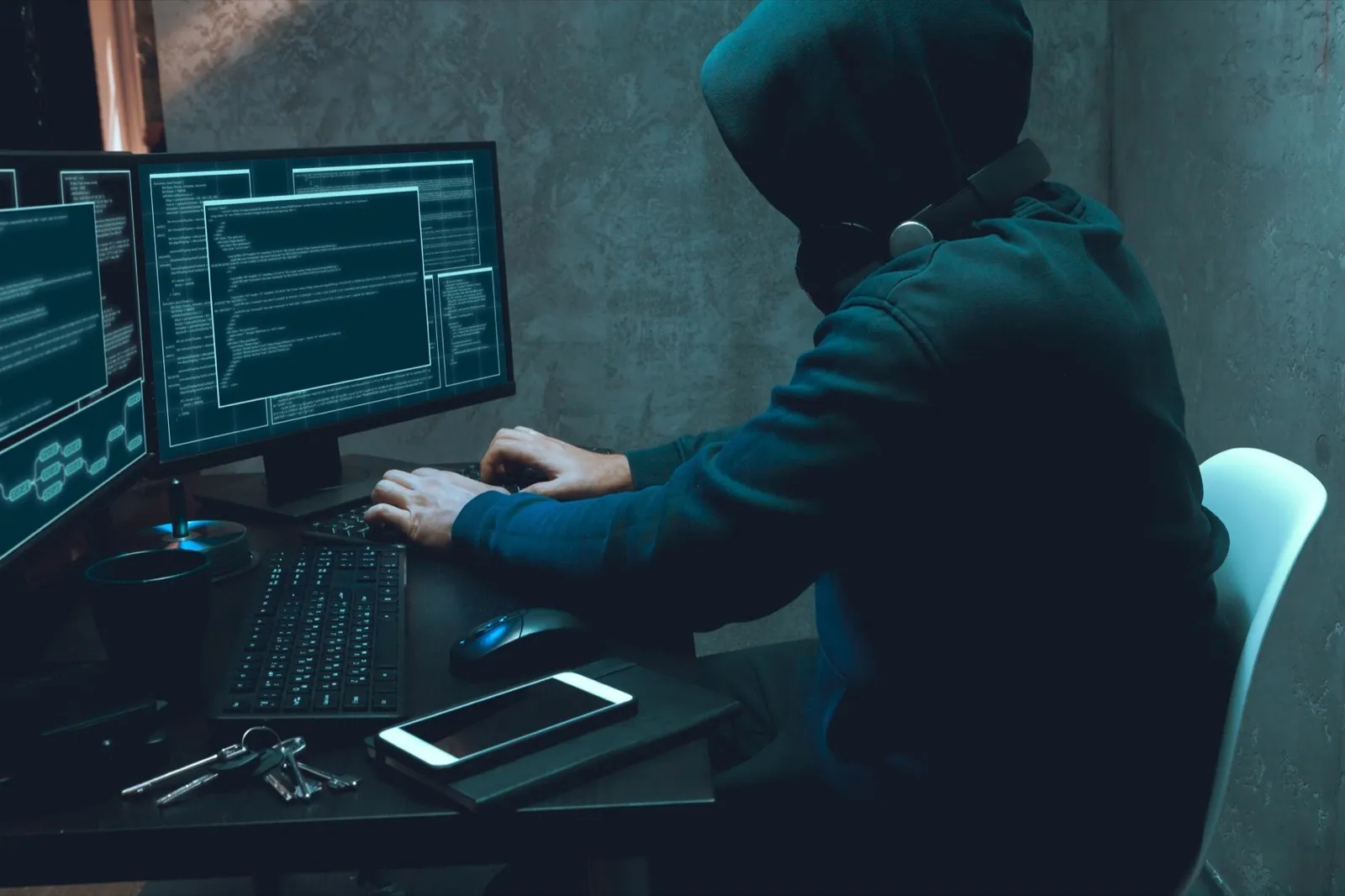 Hacker programmer using computer in dark room