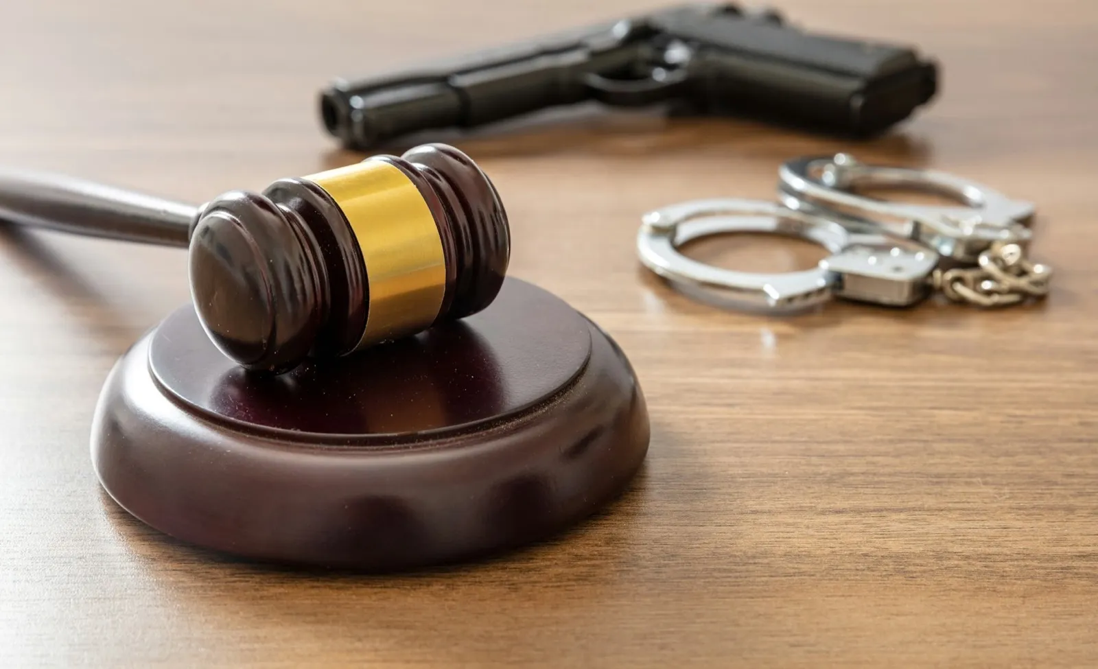Judge gavel and handgun on lawyer office, close up. Crime, murder punishment concept.