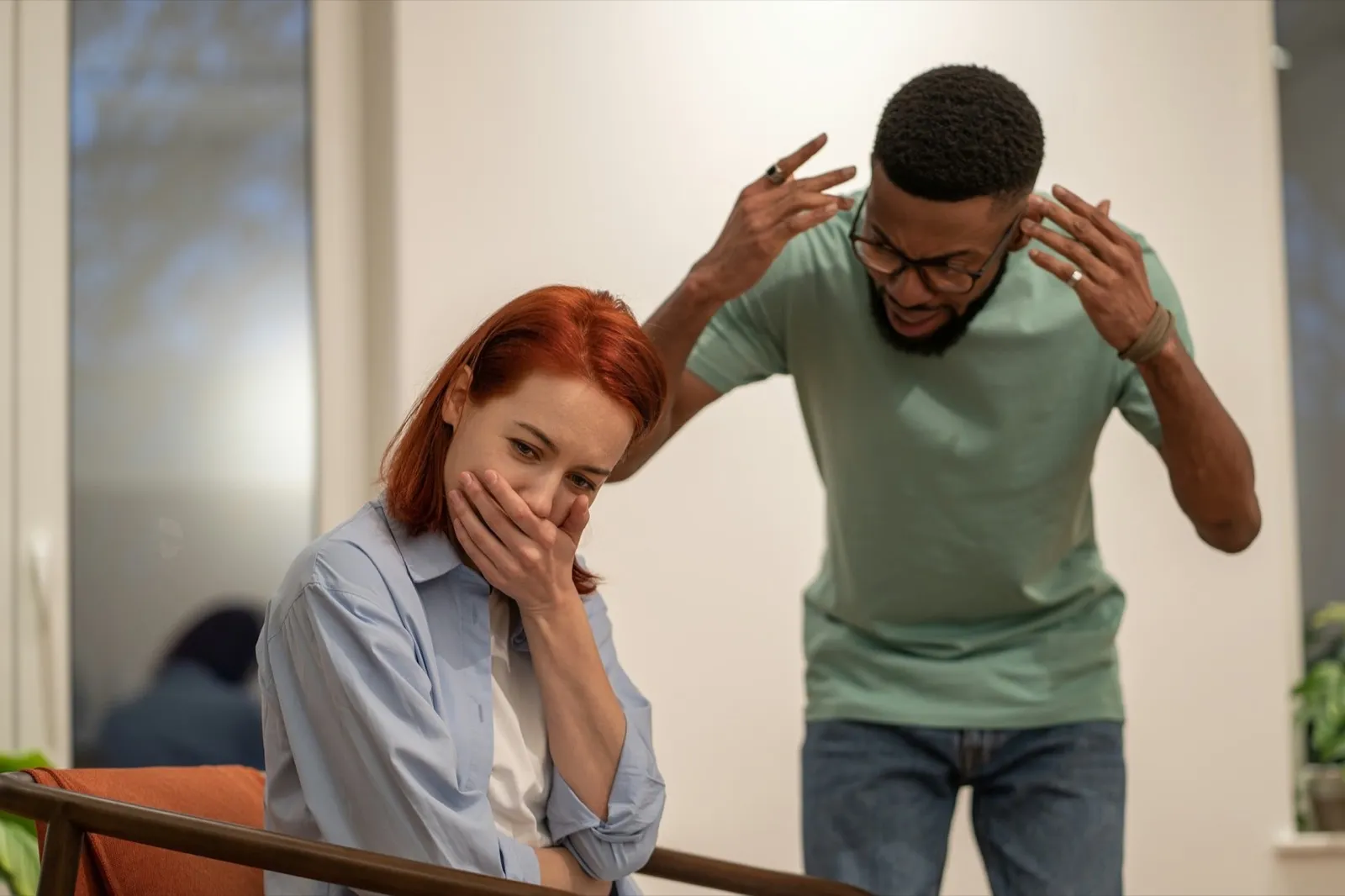 Mad angry African American man husband blaming and shaming wife at home. Domestic violence concept