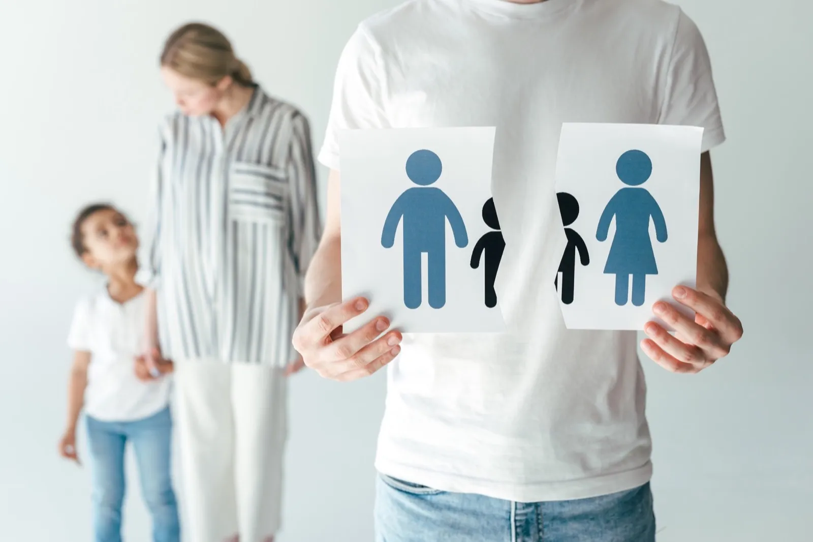 man holding ripped paper with drawn family near woman and adopted african american kid on white