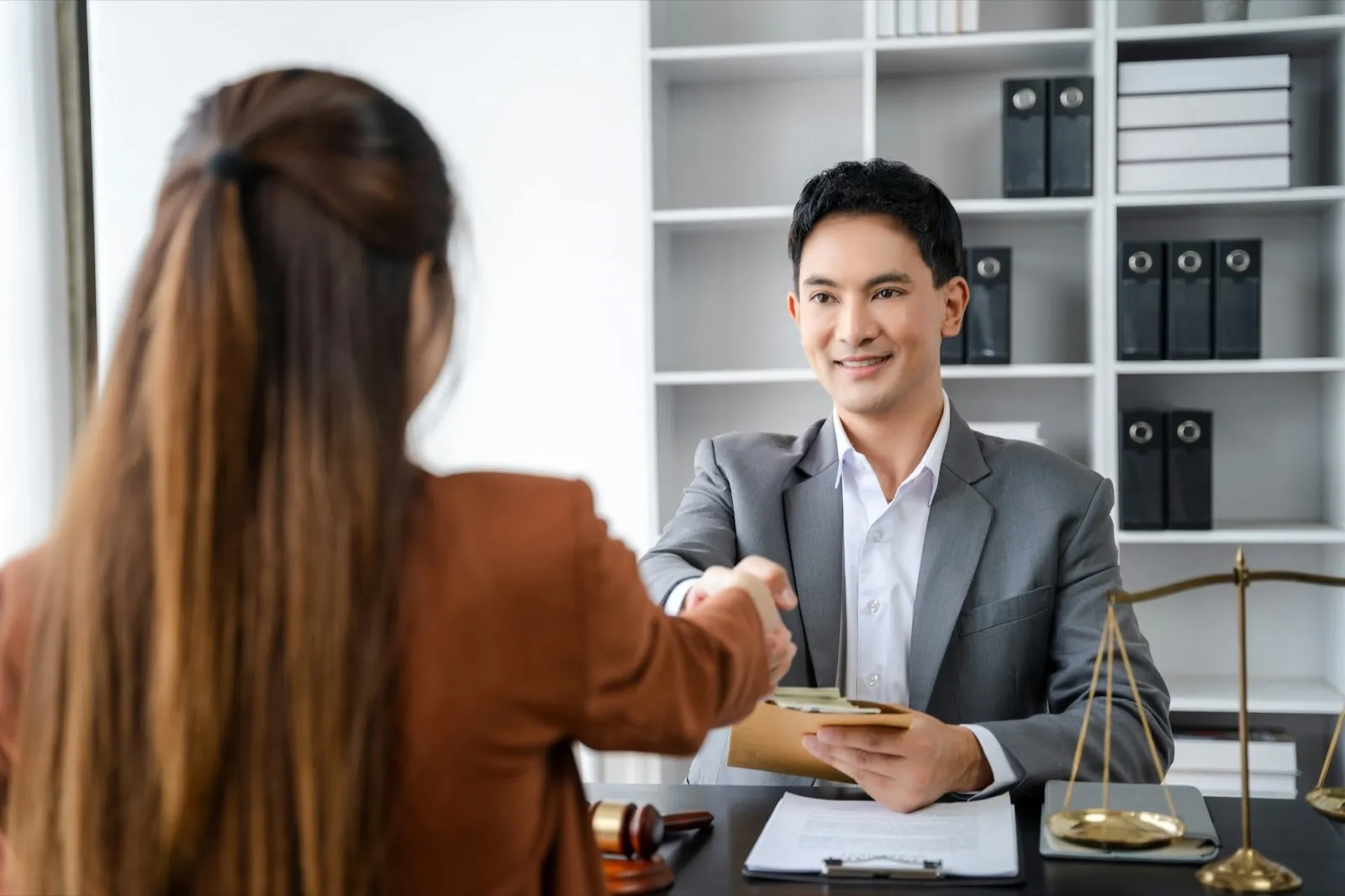 partner lawyers attorneys shaking hands after discussing a contract agreement done.