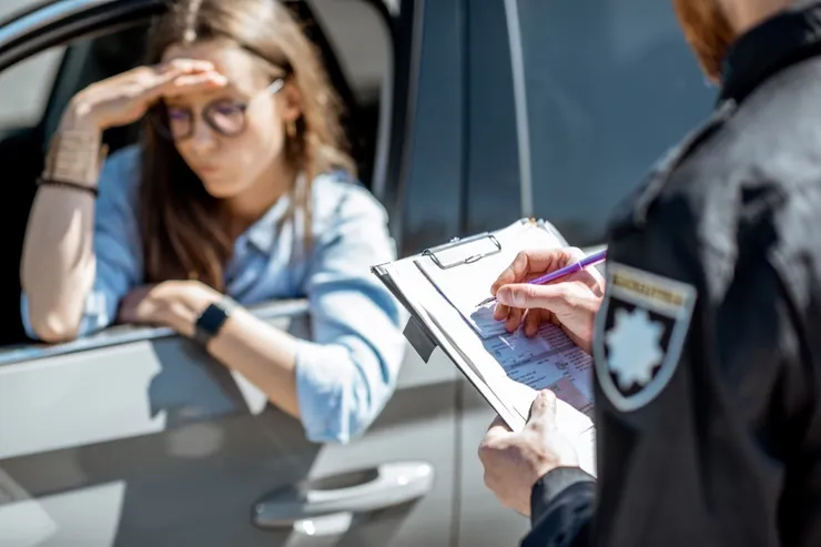 Policeman issuing a fine for a female driver