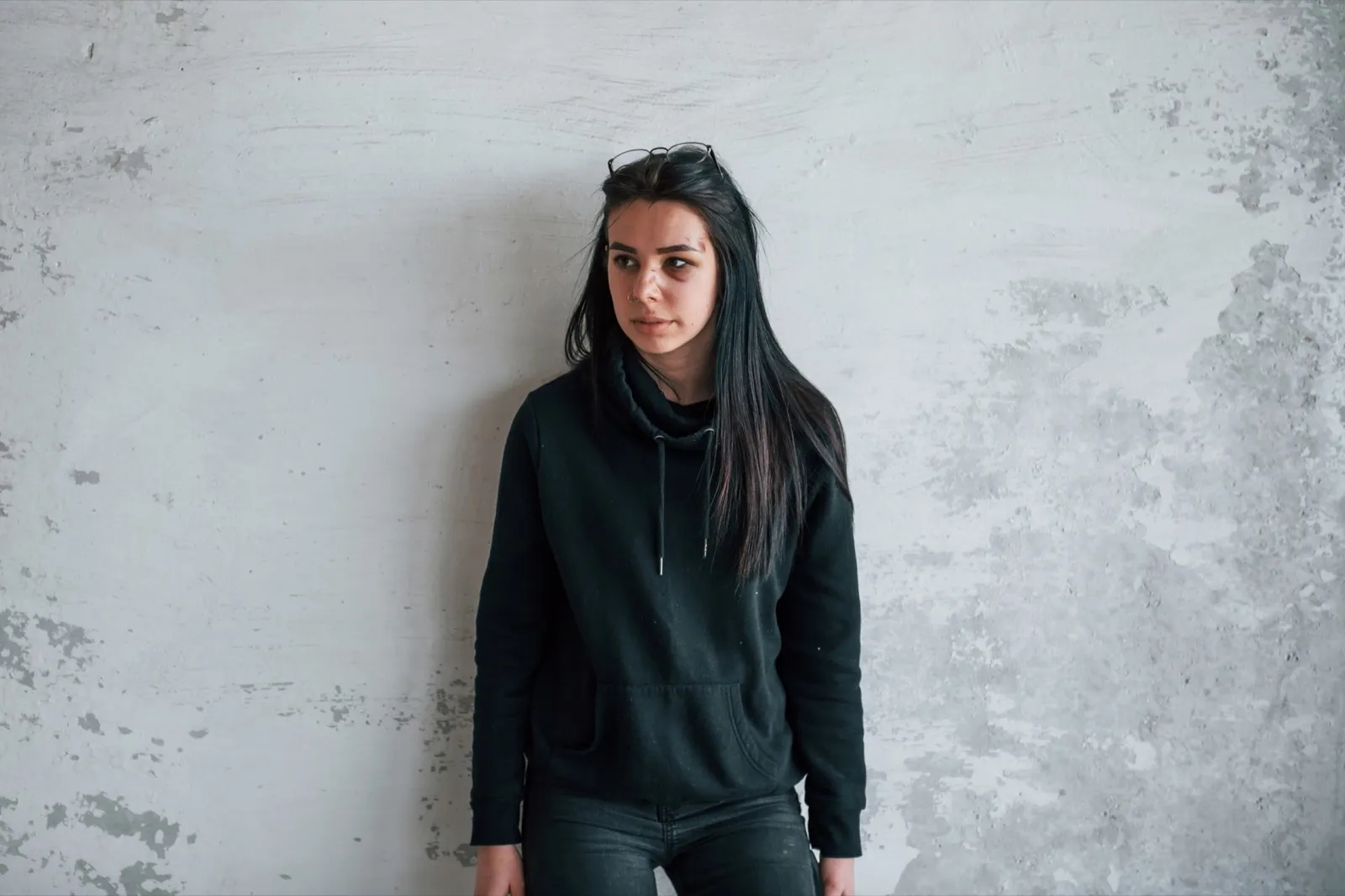 Portrait of beaten young woman with bruise under eye indoors in abandoned building