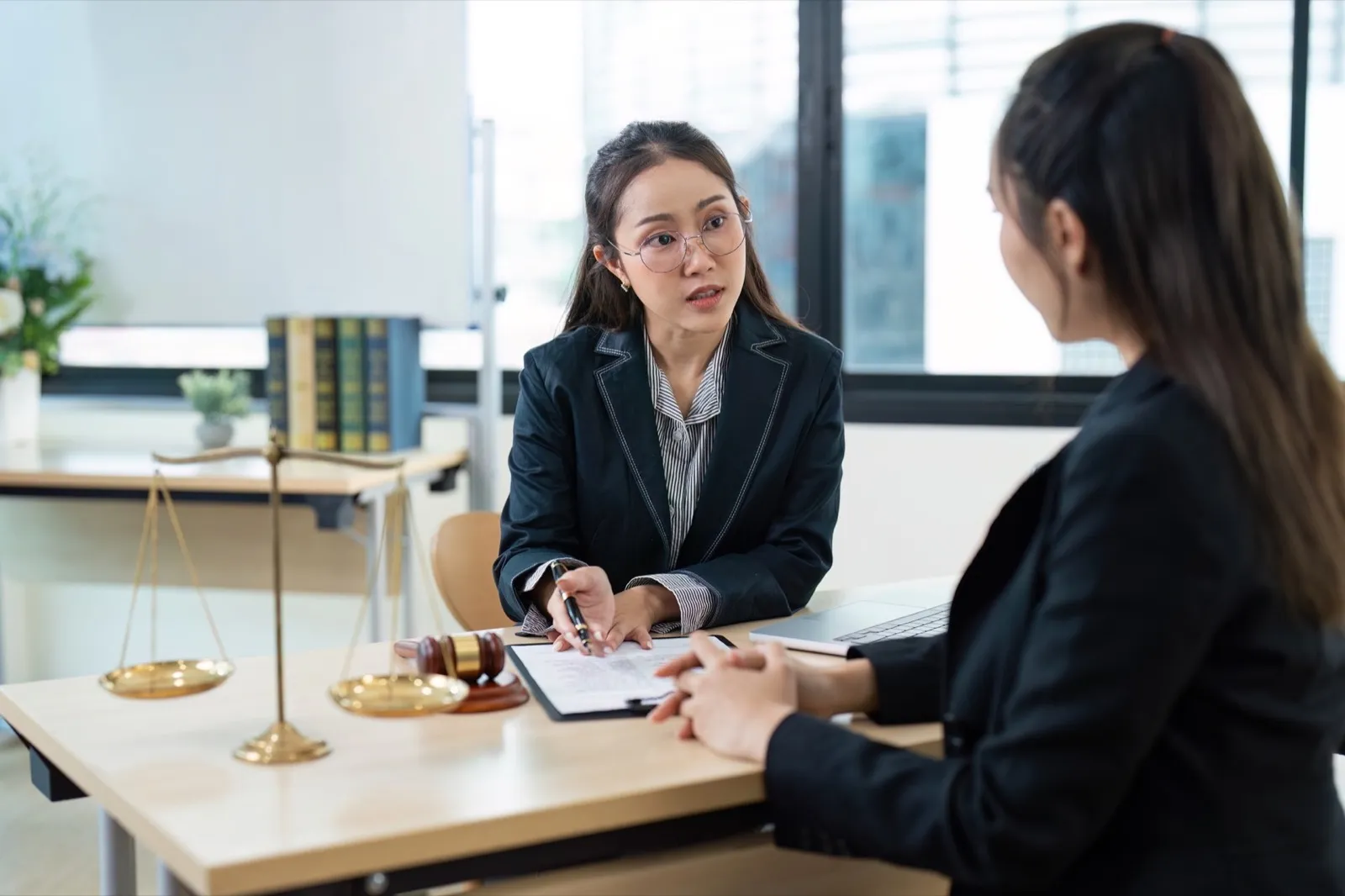 Professional Female Lawyer Consultation Client in Modern Office with Legal Documents and Scales of