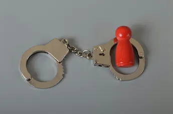 Red wooden people of figure with handcuff locked. Handcuffed convict, law offender and justice