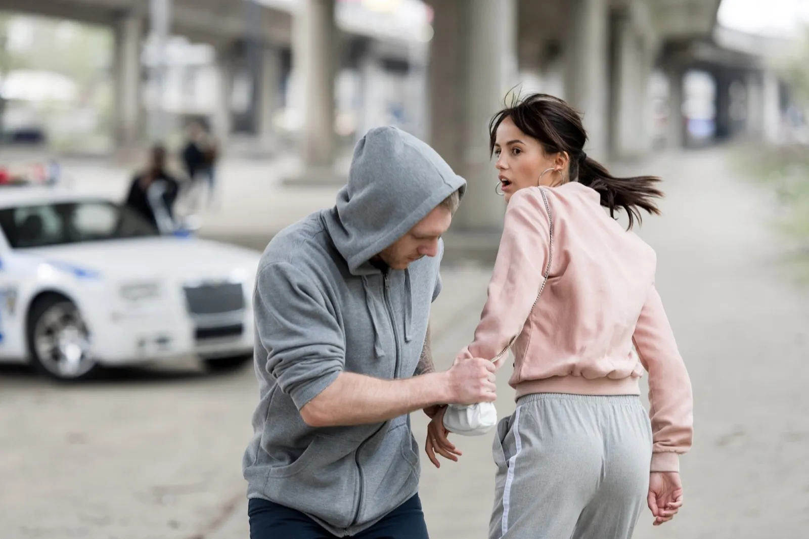 robber in hoodie stealing handbag from shocked young woman