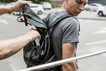robbery pickpocketing laptop from mans backpack on street
