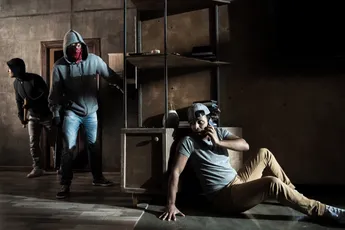 Scared man hiding from burglars breaking indoors, house robbery scene