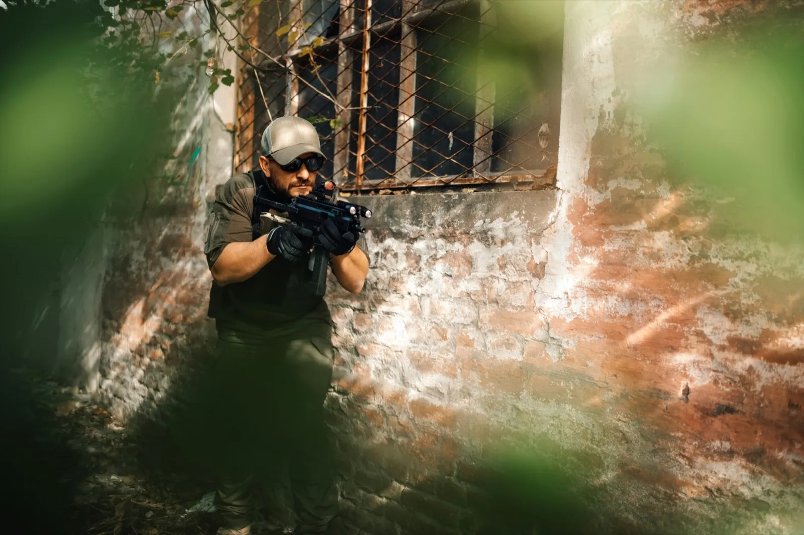 Soldier aiming with assault rifle near abandoned building