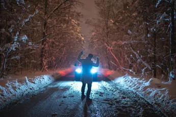 The man scared the car on the snowy road. evening night time