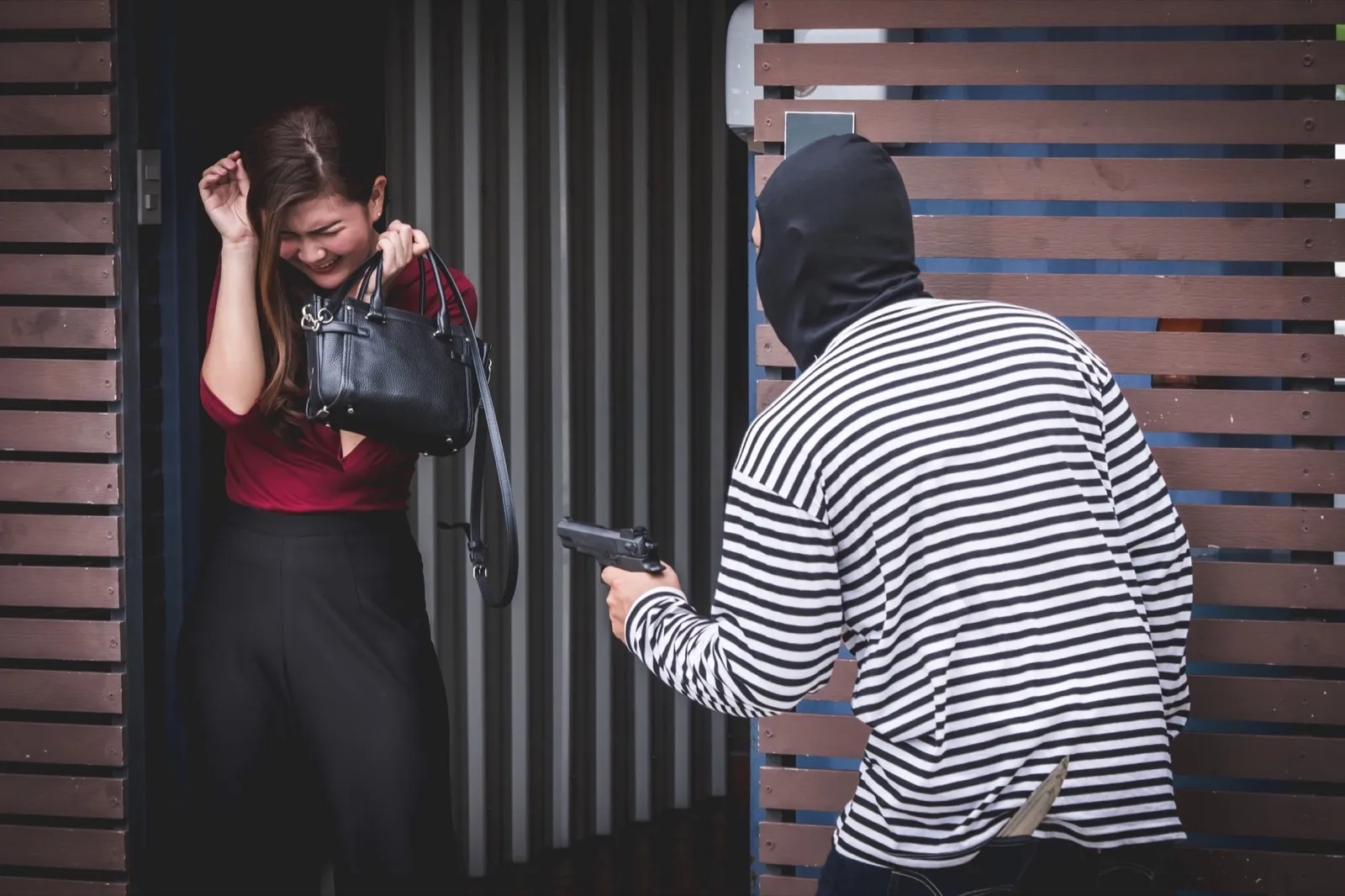 Thief is looking at an asian woman who is in a toilet alone because he want to steal her bag.