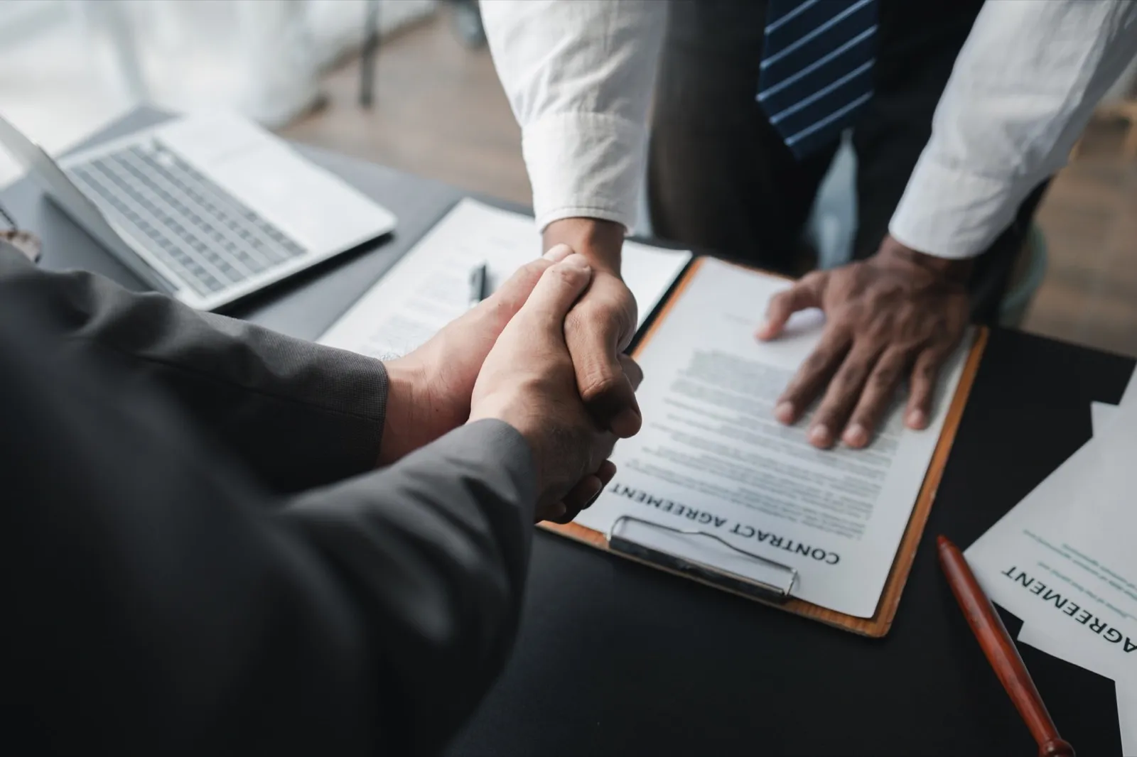 Two lawyers shake hands in a brainstorming meeting. Lawyers search for legal information together to