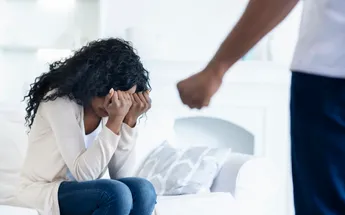 Woman hiding her face from husband's fist, suffering from abuse