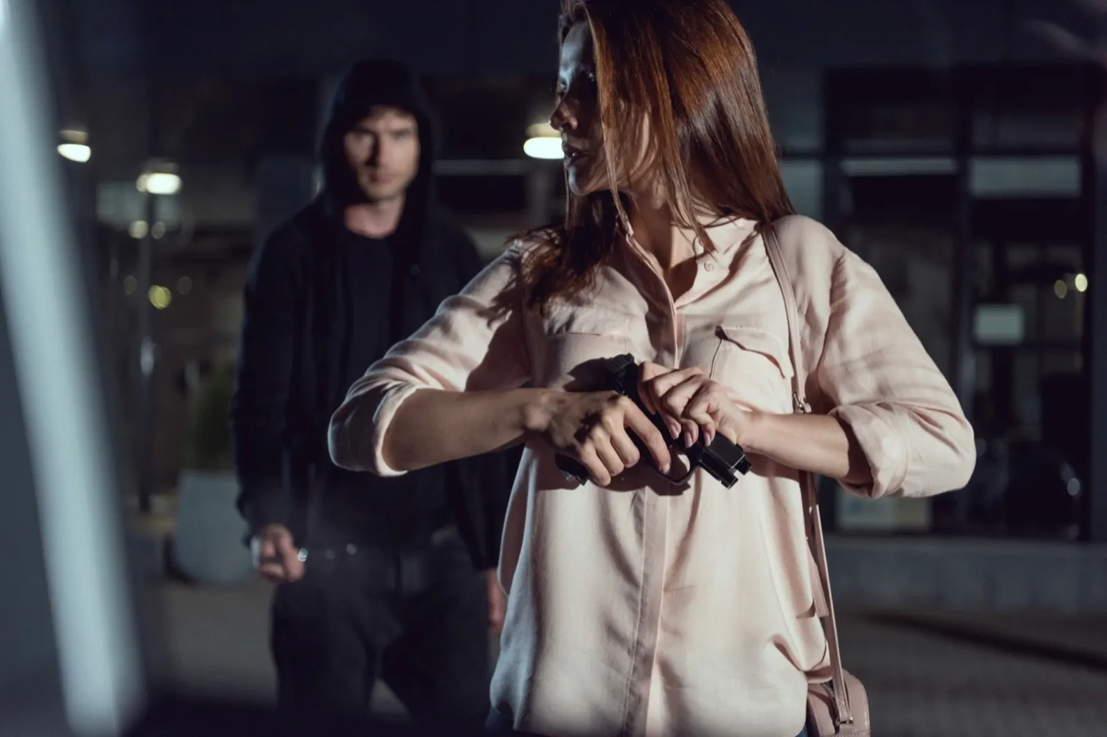 woman with gun near thief at night