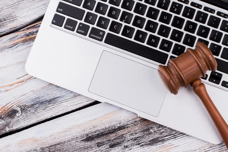 Wooden court gavel on a laptop keyboard.