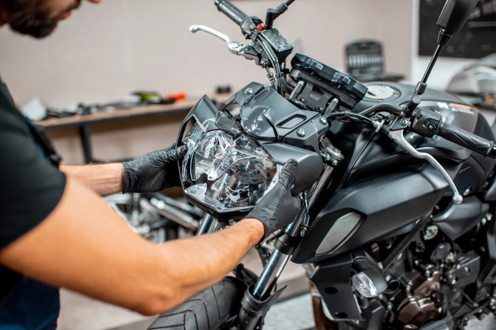 Worker repairing motorcycle headlight in the workshop